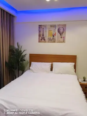 a bedroom with a bed with white sheets and posters at Bay View Resort Sahl Hashesh in Hurghada
