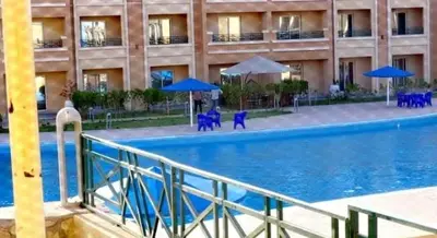 a large swimming pool in front of a building at Bay View Resort Sahl Hashesh in Hurghada