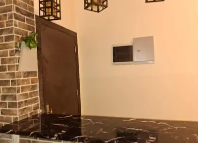 a bathroom with a black door and a brick wall at Bay View Resort Sahl Hashesh in Hurghada