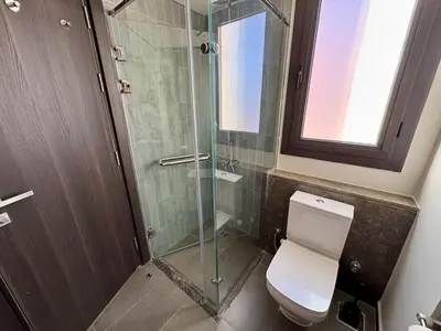 a bathroom with a toilet and a glass shower at Gouna Ancient Hill 3 BDR Nanny Privat Pool Lagoon View in El Gouna