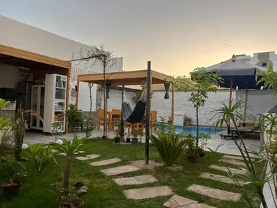 a backyard with a hammock and a swimming pool at Nile Spirit Apt 2 in Jazīrat al ‘Awwāmīyah