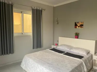 a bedroom with a white bed and two windows at Nile Spirit Apt 2 in Jazīrat al ‘Awwāmīyah