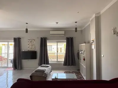 a living room with a couch and a refrigerator at Nile Spirit Apt 2 in Jazīrat al ‘Awwāmīyah