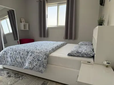 a white bed in a room with a window at Nile Spirit Apt 2 in Jazīrat al ‘Awwāmīyah