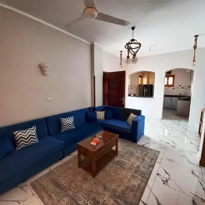 a living room with a blue couch and a table at Christine Home in Luxor