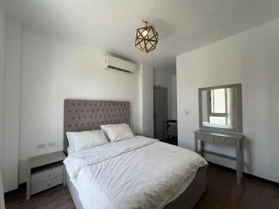 a bedroom with a large bed and a mirror at Sholan Gouna | Modern 2BR with Pool Access in Hurghada