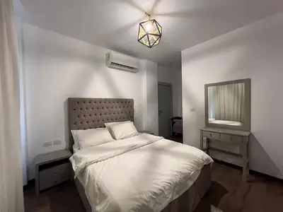 a bedroom with a large bed and a mirror at Sholan Gouna | Modern 2BR with Pool Access in Hurghada