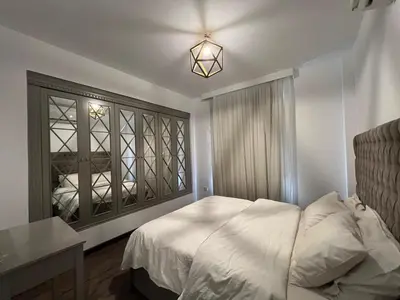 a bedroom with a white bed and a window at Sholan Gouna | Modern 2BR with Pool Access in Hurghada