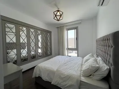 a bedroom with a bed and a desk and a window at Sholan Gouna | Modern 2BR with Pool Access in Hurghada