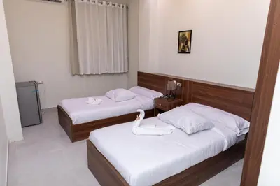 two beds in a hotel room with a swan on them at Arkan Hotel Qena in Qena