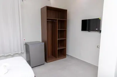 a bedroom with a book shelf and a television at Arkan Hotel Qena in Qena