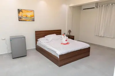 a bedroom with a bed and a trash can at Arkan Hotel Qena in Qena