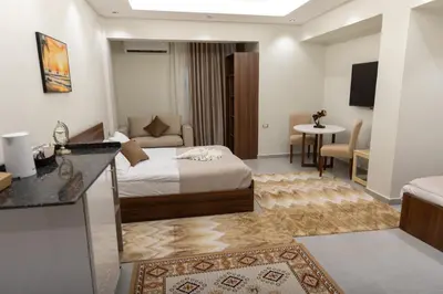 a hotel room with a bed and a living room at Arkan Hotel Qena in Qena
