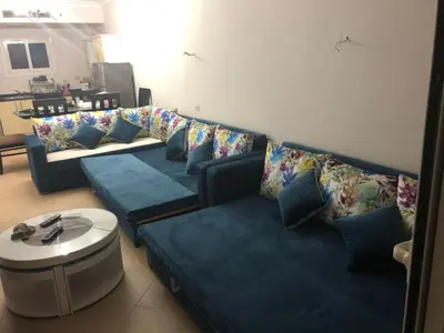a living room with a blue couch and a table at Sunset Sahl Hashesh in Hurghada