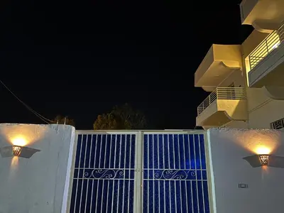a white fence with lights on top of it at night at The Nile Paradise in Al Aqālitah