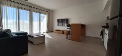 a living room with a couch and a large window at El Gouna Paradise Escape 2-Bedroom Ground Floor in El Gouna