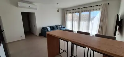 a living room with a table and a blue couch at El Gouna Paradise Escape 2-Bedroom Ground Floor in El Gouna