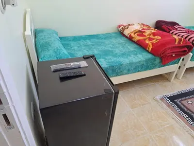 a small refrigerator in a room with a couch at Sweet Home 8 in Hurghada