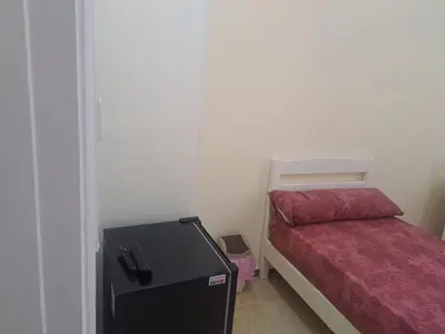 a small bedroom with a bed and a small refrigerator at Sweet Home 7 in Hurghada