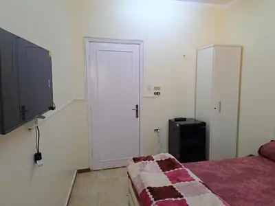 a bedroom with a bed and a door and a television at Sweet Home 7 in Hurghada