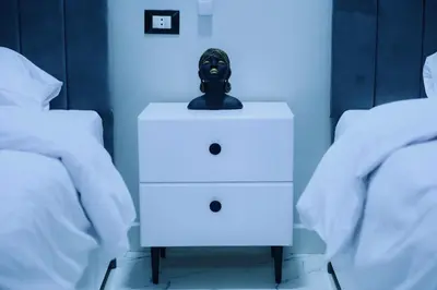 a nightstand with a mask on it next to two beds at Paradise House Holiday in Luxor