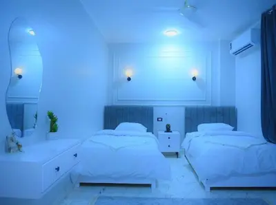 two beds in a room with blue lighting at Paradise House Holiday in Luxor