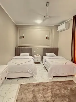 a bedroom with two beds and a mirror on the wall at Paradise House Holiday in Luxor