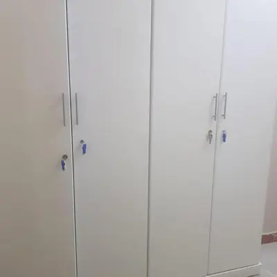 a group of four white cabinets in a room at Sweet Home Hostel in Hurghada