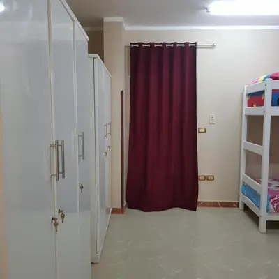 a room with a red curtain and a closet at Sweet Home Hostel in Hurghada