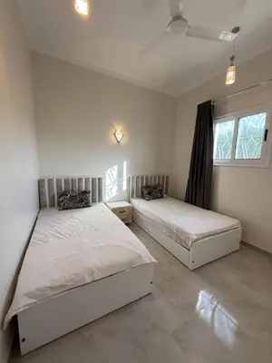 a bedroom with two beds and a window at Nefertarie Villa in Luxor