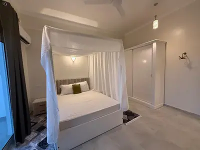 a white bed with a canopy in a room at Nefertarie Villa in Luxor