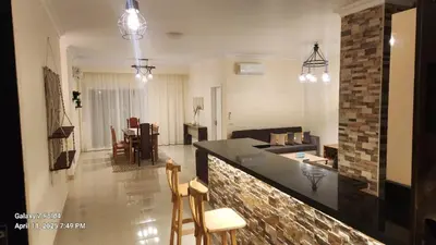 a kitchen and living room with a counter and chairs at Aldora residence شقه 3 غرف نوم و2 حمام in Hurghada