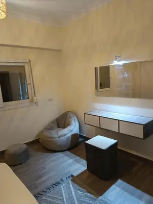 a living room with a chair and a mirror at Aldora residence شقه 3 غرف نوم و2 حمام in Hurghada