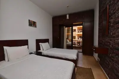 a bedroom with two beds and a brick wall at Turtles Beach Resort, Al Ahyaa in Hurghada