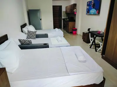 two white beds in a room with a desk at Private Beach Chalet in Orabia in Hurghada