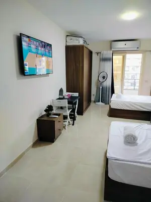 a hotel room with a bed and a desk and a tv at Private Beach Chalet in Orabia in Hurghada