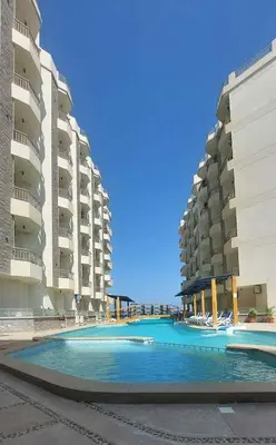 a swimming pool in front of two apartment buildings at La-Quinta Resort Erika in Hurghada