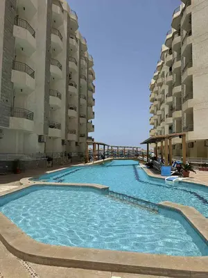 a large swimming pool next to two tall buildings at La-Quinta Resort Erika in Hurghada