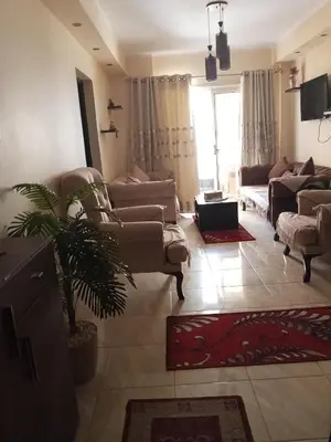 a living room with couches and a plant in it at كمبوند فلورنز in Hurghada