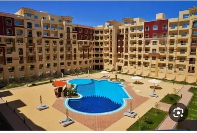 a large swimming pool in front of some apartment buildings at كمبوند فلورنز in Hurghada