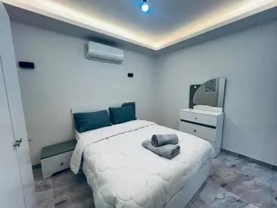 a bedroom with a white bed and a television at One bedroom and reception in Hurghada