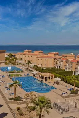 a resort with a large swimming pool next to the ocean at One bedroom and reception in Hurghada