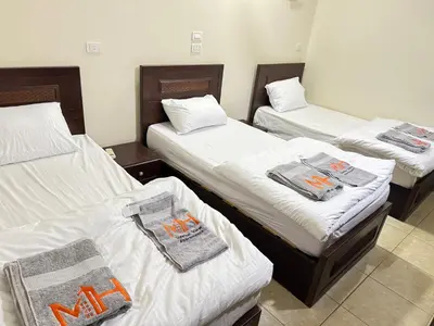 three beds in a room with towels on them at Safaga SeaView Rooftop in Safaga