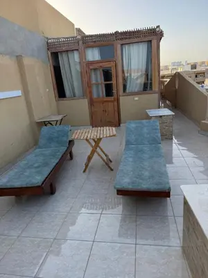a patio with two benches and a table on a roof at Safaga SeaView Rooftop in Safaga