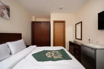 a bedroom with a white bed and a sink at Elyasmene in Qena