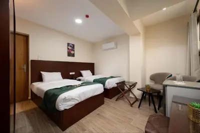 a hotel room with two beds and a desk at Elyasmene in Qena