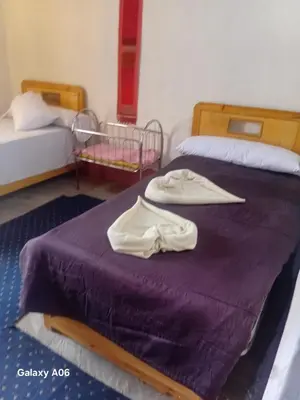 a bedroom with two beds with towels on a purple bed at Mountain guest house in Luxor