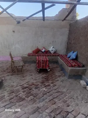 a room with a bed and a table and a chair at Mountain guest house in Luxor