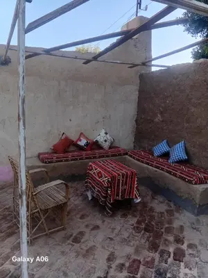 a room with two beds and a table and chairs at Mountain guest house in Luxor