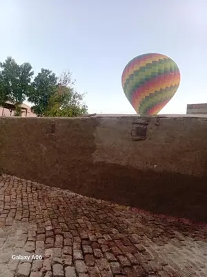 a hot air balloon flying over a brick wall at Mountain guest house in Luxor